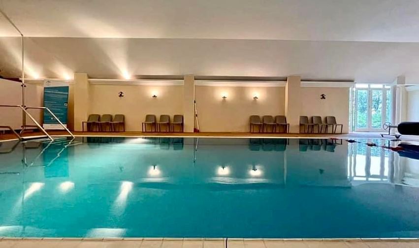 The indoor swimming pool at House of Schivas, with seating along the poolside