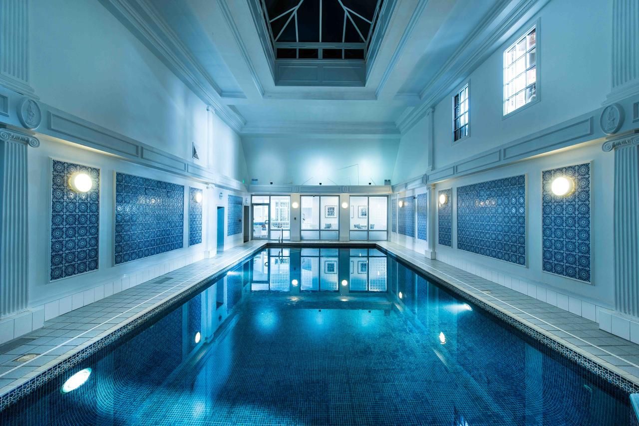 The indoor swimming pool at Thainstone House Hotel, beneath a high ceiling and tall windows