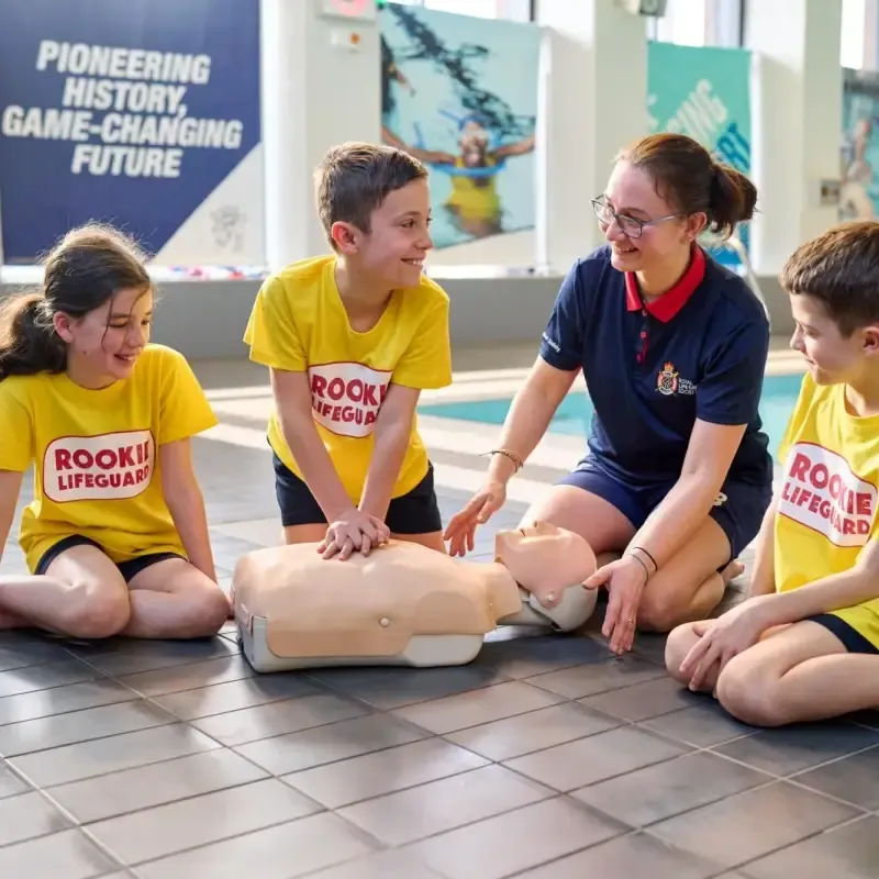 Children practising first aid with an RLSS UK instructor and a training manikin